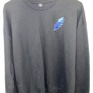 May include: Black sweatshirt with a blue and white lightning bolt graphic on the front.