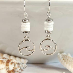 May include: Silver dangle earrings with white shell beads and a silver wave charm.