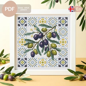 May include: A framed cross-stitch pattern depicting an olive branch with green and purple olives. The background features a repeating geometric design in blue, yellow, and white. The text "PDF Cross stitch pattern" is visible.