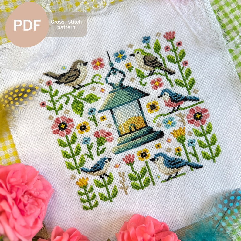 May include: Cross stitch pattern PDF for a colorful birdhouse scene with bluebirds, a green birdhouse, and flowers. The pattern is on a white background.