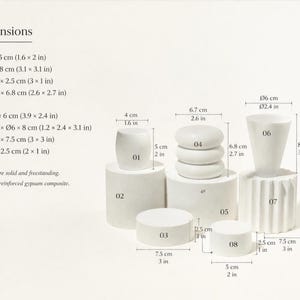 Puede incluir: Colecci&oacute;n de esculturas geom&eacute;tricas blancas de compuesto de yeso de varias formas. Incluye formas cil&iacute;ndricas, redondeadas y apiladas, con dimensiones que var&iacute;an de 4 cm a 10 cm de altura y anchura. Las piezas son s&oacute;lidas y exentas.