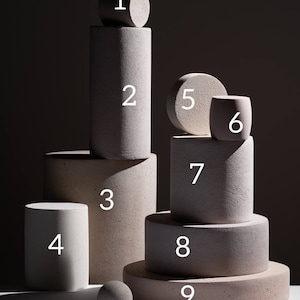Ten numbered concrete display podiums showing all available sizes from small to large on dark background