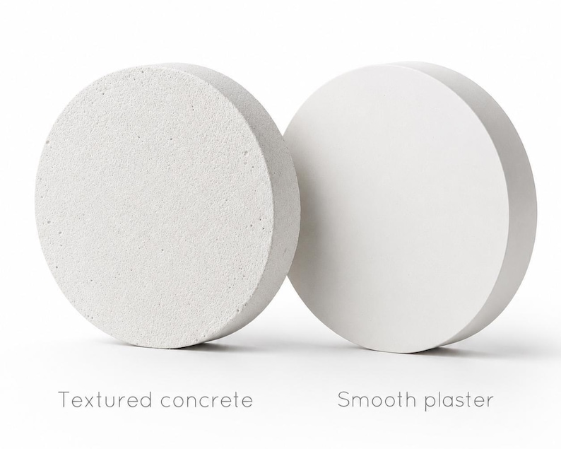 Pode incluir: Dois objetos circulares, um com superf&iacute;cie de concreto texturizado, o outro com acabamento de gesso liso. O texto abaixo diz "Textured concrete" e "Smooth plaster". Os objetos s&atilde;o de cor branco sujo.