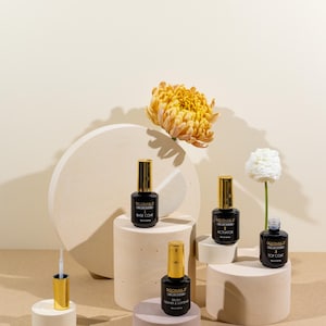 Concrete display risers used as product photography props with nail polish bottles and beauty products on beige background