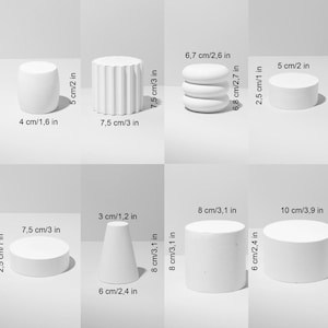 Puede incluir: Una colecci&oacute;n de formas geom&eacute;tricas blancas, incluyendo cilindros, un cono y formas ovaladas apiladas. Las medidas se proporcionan en cm y pulgadas, con la pieza m&aacute;s alta de 7,5 cm (3 pulgadas) de altura. Los objetos est&aacute;n dispuestos sobre un fondo claro.