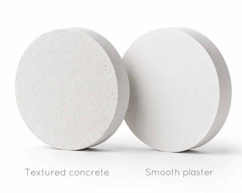 Puede incluir: Dos objetos circulares, uno con una superficie de hormig&oacute;n texturizado y otro con una superficie de yeso liso. El texto de abajo dice "Textured concrete" y "Smooth plaster".