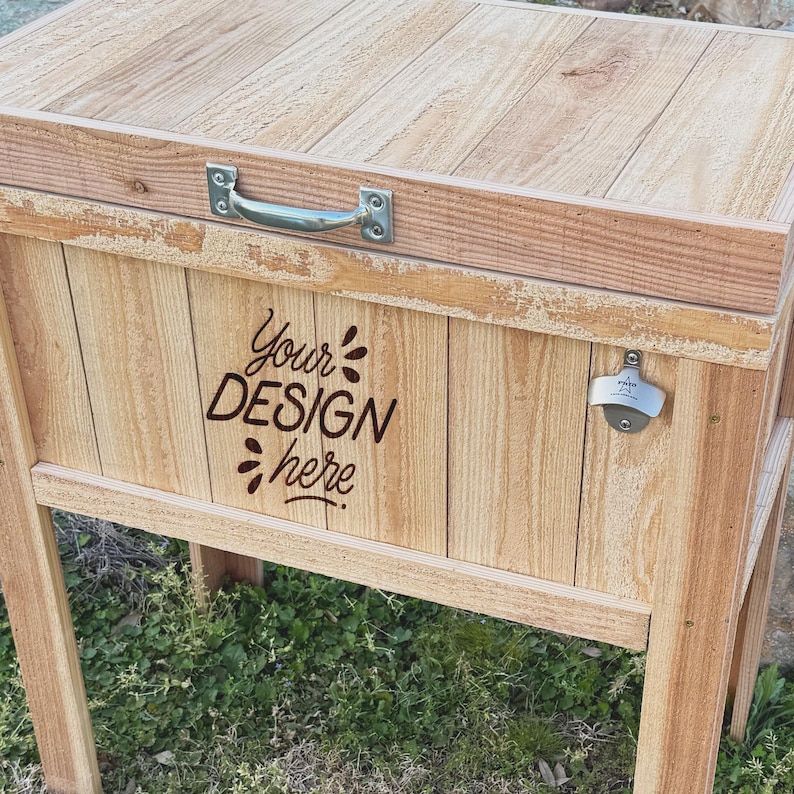 Pode incluir: Frigor&iacute;fico de madeira com tampa articulada, pega de metal e abridor de garrafas. O frigor&iacute;fico tem um acabamento de madeira e o texto "Your Design Here" est&aacute; gravado na frente.