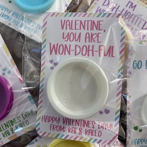 May include: Valentine's Day gifts featuring small Play-Doh containers in various colors. Each is packaged with a card that reads "Valentine, you are won-doh-ful" and "Happy Valentine's Day from Kai & Kaleo."
