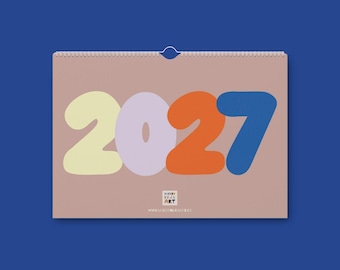 May include: A wall calendar for the year 2027 with a dusty pink background. The numbers 2027 are displayed in large, rounded, colorful fonts: yellow, light purple, orange, and blue. A small logo reads MODERN KIDS ART with a website address below.