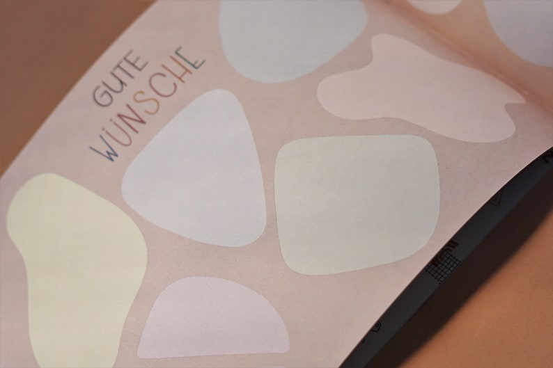 May include: A pink background with the text "GUTE W&Uuml;NSCHE" in blue and white lettering. There are five white, cream, and light pink abstract shapes on the background.