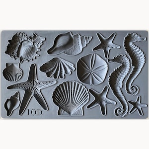 May include: A gray silicone mold with 12 different sea-themed shapes, including starfish, seashells, and seahorses. The mold is labeled "IOD".