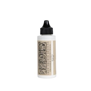 May include: A white plastic squeeze bottle with a black pointed cap, containing Iron Orchid Designs erasable liquid chalk in white. The label features the text IOD, Iron Orchid Designs, Erasable Liquid Chalk, White, and 2 fl oz.
