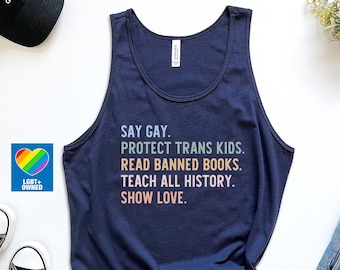 Puede incluir: Un top sin mangas azul marino con el texto "Say Gay. Protect Trans Kids. Read Banned Books. Teach All History. Show Love." impreso en colores arcoíris. El top sin mangas se fotografía sobre un fondo blanco con unas gafas de sol, una gorra negra, un par de zapatillas negras, unos pantalones cortos de mezclilla azul y una pequeña pegatina de corazón arcoíris con el texto "LGBT+ Owned".
