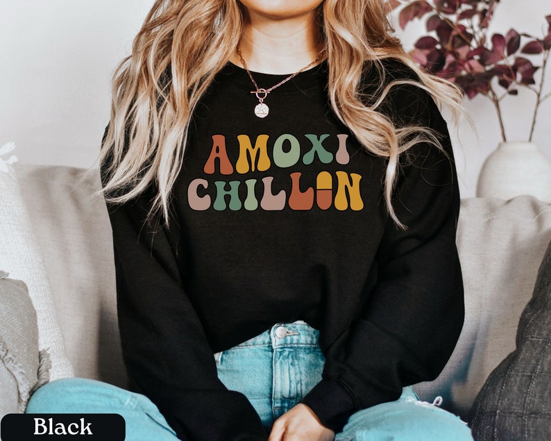 May include: A black sweatshirt with the text "AMOX! CHILLIN" in colorful retro font.