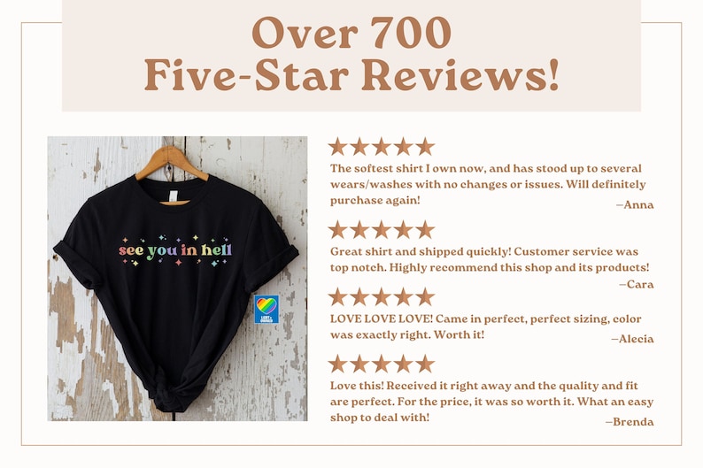 Puede incluir: Camiseta negra con el texto "see you in hell" en colores arco&iacute;ris. La camiseta est&aacute; en una percha y tiene un logotipo de coraz&oacute;n arco&iacute;ris en la esquina inferior derecha. La imagen est&aacute; acompa&ntilde;ada de rese&ntilde;as de cinco estrellas de los clientes.