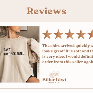 K&ouml;nnte beinhalten: Ein beiger Pullover mit dem Aufdruck "I CAN'T. I HAVE PICKLEBALL." auf der Vorderseite. Der Pullover wird von einer Person modelliert. Das Bild zeigt au&szlig;erdem eine F&uuml;nf-Sterne-Bewertung und eine Rezension, die lautet: "Das Shirt kam schnell an und sieht toll aus! Es ist weich und die Farbe ist sehr sch&ouml;n. Ich w&uuml;rde auf jeden Fall wieder bei diesem Verk&auml;ufer bestellen!" Die Rezension stammt von Killer Kiwi Design Co.