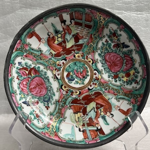 May include: A vintage Chinese porcelain bowl with a pewter rim. The bowl features a colorful floral design with figures in red, green, and gold.