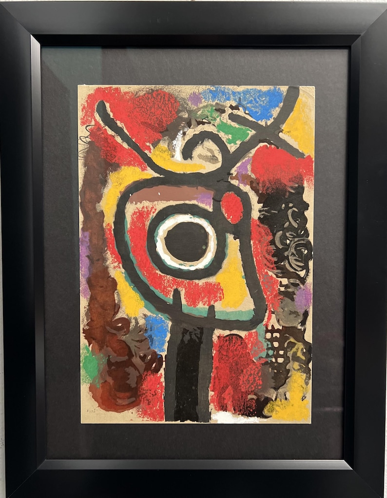 May include: Abstract art print with a colorful, geometric design. The print features a central circle with a black center and a white ring, surrounded by red, yellow, green, and blue shapes. The print is framed in black.