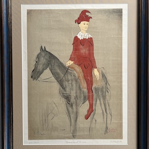 May include: A black and white lithograph print of a man in a red jester costume riding a horse. The print is titled "Cheval et Clown" and signed "Picasso".