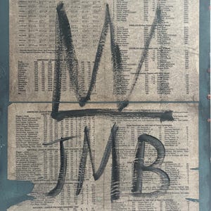 May include: Artwork featuring a vintage baseball schedule from 1983, overlaid with bold black graffiti-style lettering. The text "M JMB" is prominently displayed, adding an urban art aesthetic to the aged paper background.