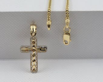 May include: A gold cross pendant with a detailed design, featuring a chain with a lobster clasp. The chain and pendant are marked with "10K".