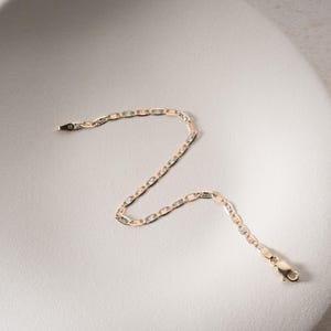 Puede incluir: Una delicada pulsera de cadena con eslabones ovalados y rectangulares alternos en un dise&ntilde;o de metal tricolor en tonos oro amarillo, rosa y blanco. La pulsera incluye un cierre de mosquet&oacute;n seguro en un extremo y una peque&ntilde;a anilla.