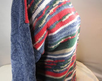 May include: A blue, red, green, white, and beige striped sweater with a mock neck.