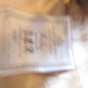 May include: A white fur coat with a white label that says "Furrier to the Stars" and "Made in Italy".