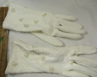 May include: A pair of white gloves with pearl-like embellishments. The gloves are made of a soft, stretchy fabric and have a delicate, feminine look.