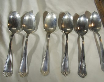 May include: Set of six silver teaspoons with ornate handles. The spoons are all polished and shiny.