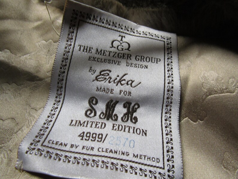 May include: White tag with black text that reads "The Metzger Group Exclusive Design by Erika Made For SMH Limited Edition 4999/2570 Clean by Fur Cleaning Method".