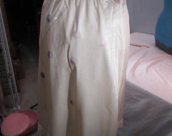 May include: A white satin slip skirt with a lace waistband and hem. The skirt has a polka dot pattern with pink and gray dots.