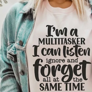 Puede incluir: Una camiseta blanca con texto negro que dice "Soy una multitarea, puedo escuchar, ignorar y olvidar todo al mismo tiempo".