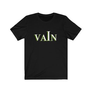 Puede incluir: Camiseta negra con la palabra "VAIN" impresa en blanco con un contorno verde.