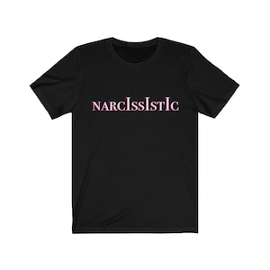 Puede incluir: Camiseta negra con la palabra "NARCISSISTIC" impresa en rosa en la parte delantera.