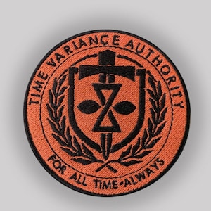 Könnte beinhalten: Runder, orangefarbener Aufnäher mit schwarzem, gesticktem Text und Design. Der Text lautet "TIME VARIANCE AUTHORITY" am Rand und "FOR ALL TIME-ALWAYS" unten. Das zentrale Design zeigt eine stilisierte Sanduhr und ein Kreuz.