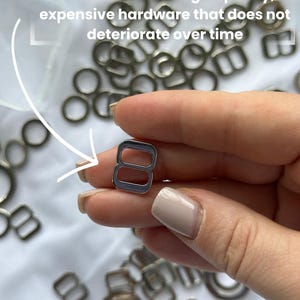May include: A close-up of various silver-colored metal hardware pieces, including rings and rectangular sliders. One slider is held between fingers. The text in the image reads: "The set includes high-quality, expensive hardware that does not deteriorate over time."