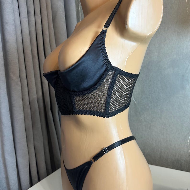 May include: Black lingerie set with a satin and mesh bra and a matching thong.