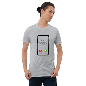 May include: A gray t-shirt with a black and white illustration of a smartphone with the text "Scam Unlikely mobile" and a red decline button and a green accept button.