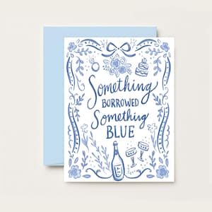May include: A white card with blue floral illustrations and the text "Something Borrowed Something Blue". The card features a bottle of champagne, two champagne glasses, a wedding cake, and a ring.