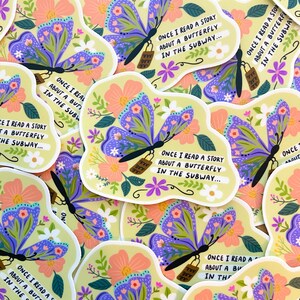 May include: A close-up of several colorful stickers featuring a butterfly with flowers and the text "Once I read a story about a butterfly in the subway..."