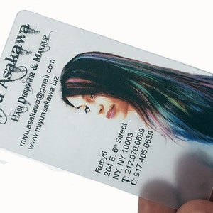 K&ouml;nnte beinhalten: Eine wei&szlig;e Visitenkarte mit schwarzem Text und einem Foto einer Frau mit langen, bunten Haaren. Der Text enth&auml;lt den Namen "Miyu Asakawa", den Titel "Hair Designer & Makeup", die Website "www.miyuasakawa.biz", die E-Mail-Adresse "miyu.asakawa@gmail.com", die Adresse "204 E. 6th Street, NY, NY 10003", die Telefonnummer "212.979.0899" und die Mobiltelefonnummer "917.405.6639".