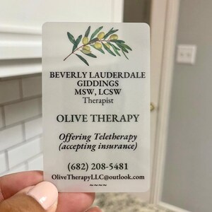 K&ouml;nnte beinhalten: Eine matte Visitenkarte mit einer Illustration eines Olivenzweigs. Der Text lautet "Beverly Lauderdale Giddings MSW, LCSW Therapist Olive Therapy Offering Teletherapy (accepting insurance) (682) 208-5481 OliveTherapyLLC@outlook.com NNN~"
