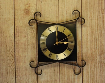 Pequeño reloj de pared hecho a mano con volutas de metal
