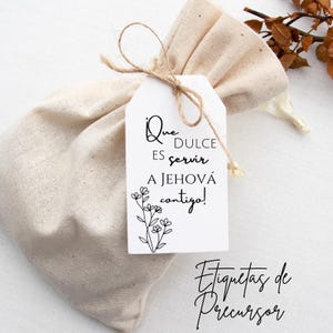 Puede incluir: Una etiqueta blanca con texto negro y un diseño floral. El texto dice "¡Que dulce es servir a Jehová contigo!" La etiqueta está atada a una pequeña bolsa de tela beige. El texto "Etiquetas de Precursor" es visible en la esquina inferior derecha de la imagen.