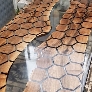 Puede incluir: Una tapa de mesa de madera con un dise&ntilde;o de panal de abeja incrustado en la superficie. El dise&ntilde;o de panal de abeja est&aacute; relleno de resina epoxi transparente, creando un efecto de r&iacute;o.