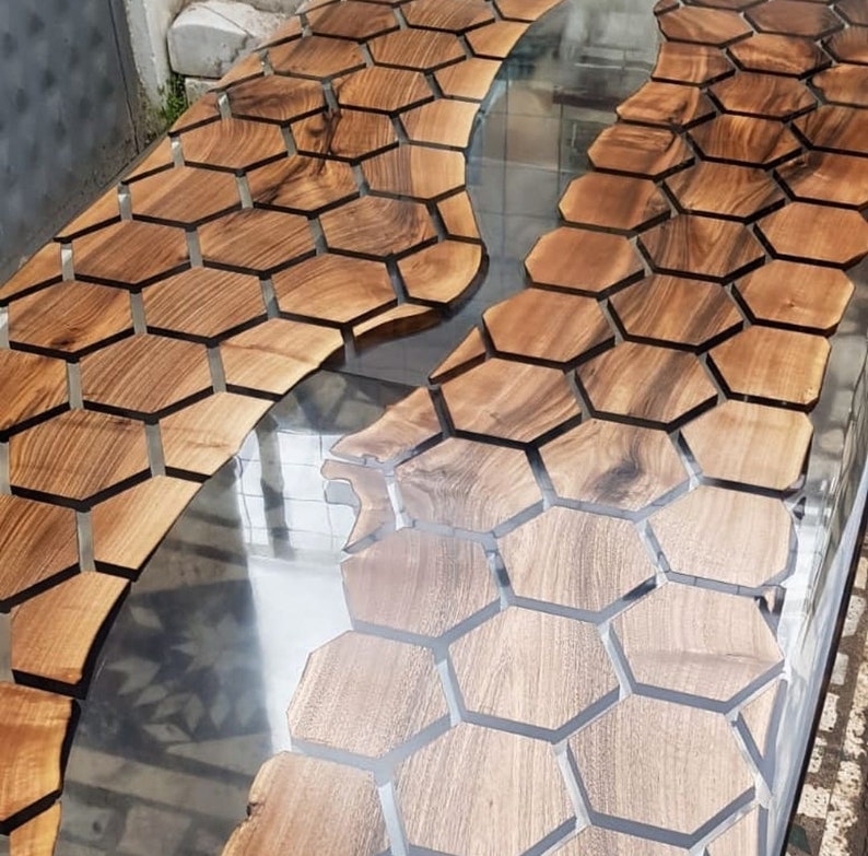Puede incluir: Una tapa de mesa de madera con un dise&ntilde;o de panal de abeja incrustado en la superficie. El dise&ntilde;o de panal de abeja est&aacute; relleno de resina epoxi transparente, creando un efecto de r&iacute;o.