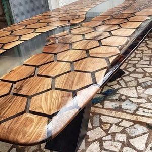Puede incluir: Una mesa de madera con un patr&oacute;n de panal de abeja incrustado con resina epoxi transparente. La mesa tiene una base de metal negro.