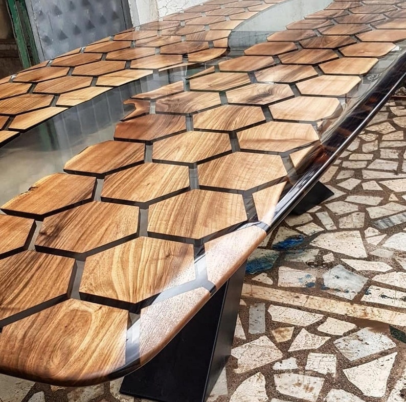 Puede incluir: Una mesa de madera con un patr&oacute;n de panal de abeja incrustado con resina epoxi transparente. La mesa tiene una base de metal negro.