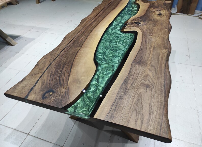 May include: A wooden table with a live edge and a green epoxy river running through the center.